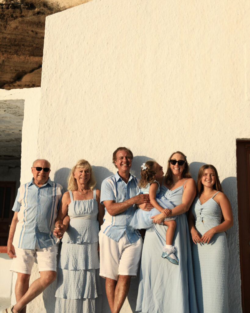 family posing for family portrait in Santorini Greece