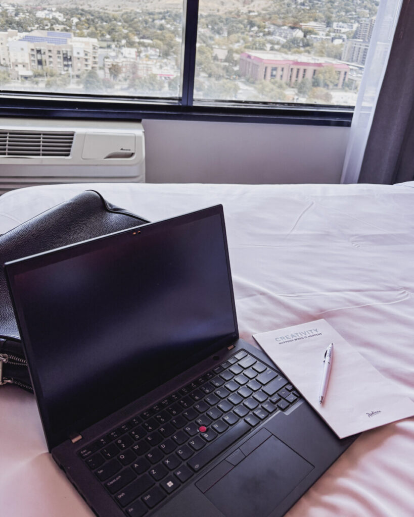 Laptop calendar, a handwritten budget list, on a bed during multigenerational trip planning