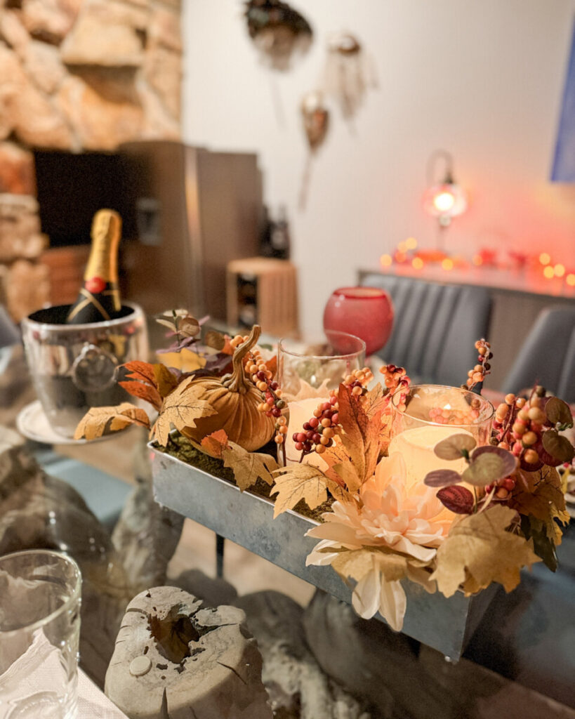 A long outdoor dinner table set for ten with serving dishes of food in late afternoon light on a family holiday trip